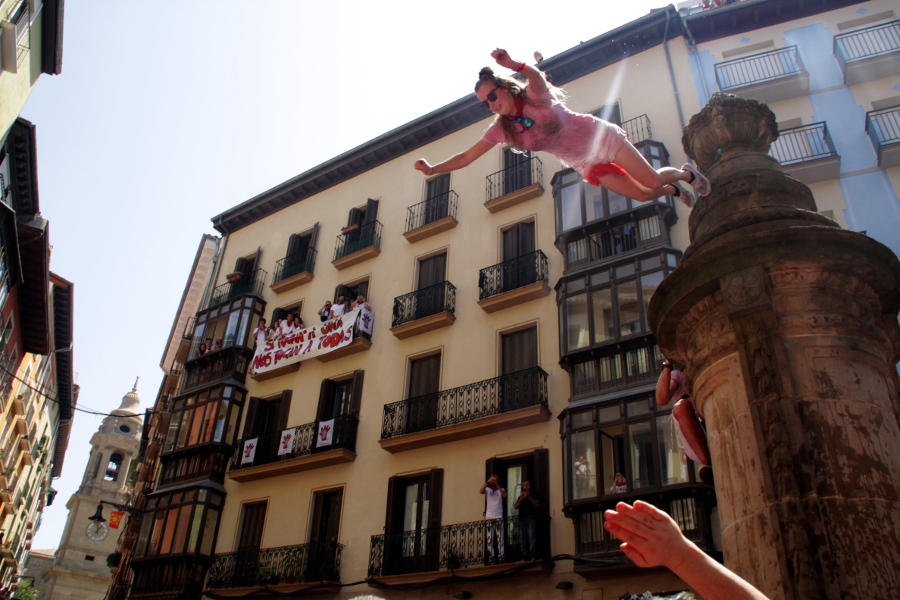 Joven efectuando el conocido como "salto del guiri" en la Fuente de Navarrería