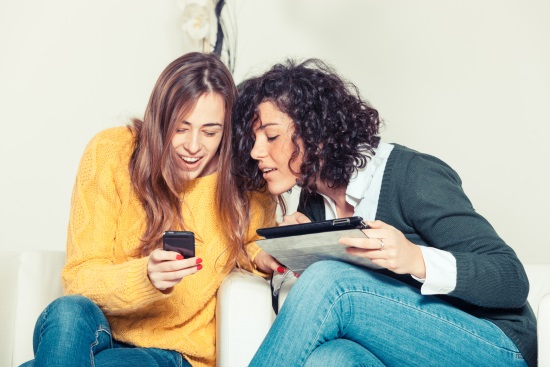 chicas-consultando-móvil-tablet