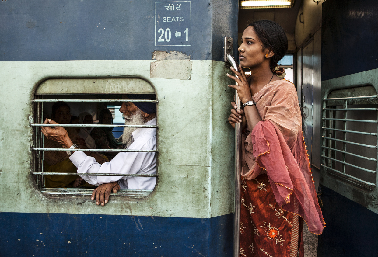 Mujer india esperando la partida del tren
