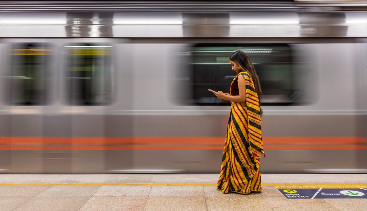 Mujer esperando el tren en la India
