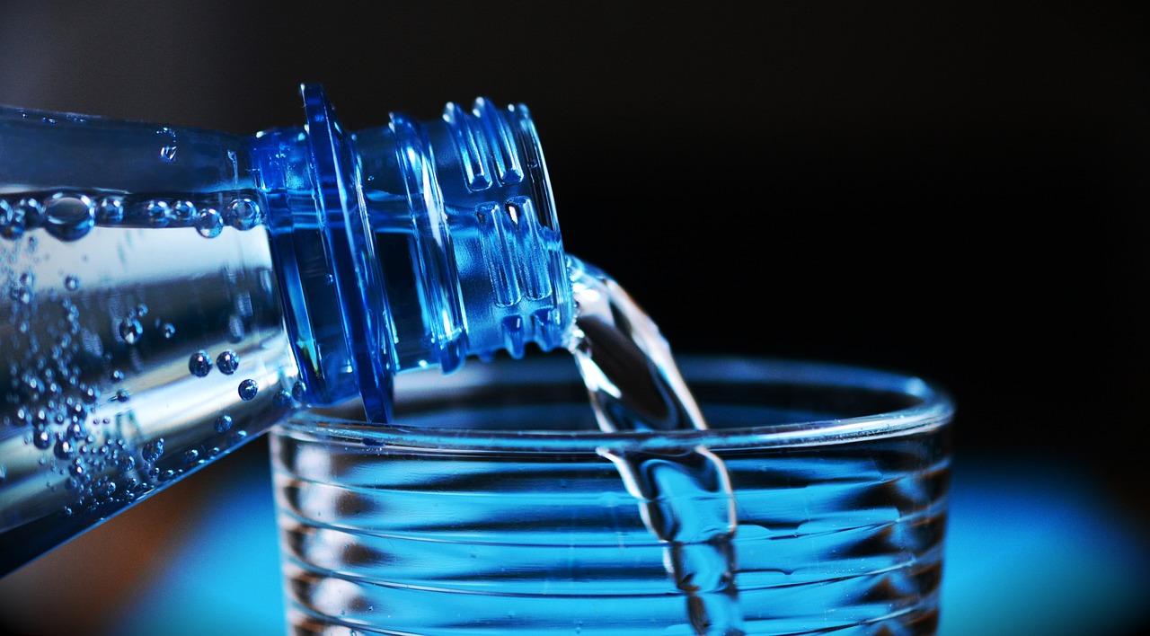 Sirviéndose agua embotellada en un vaso