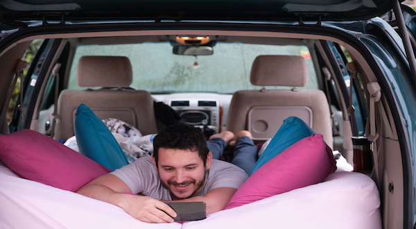 Chico con todo preparado para dormir en el coche