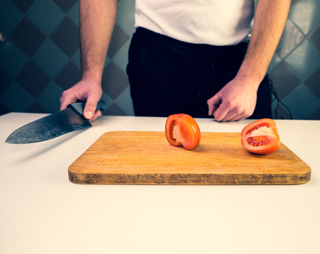 En la cocina cortando un tomate
