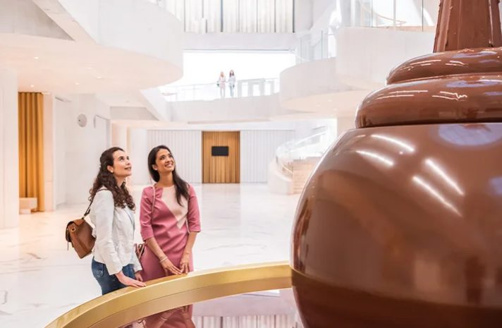 Chicas mirando la fuente de chocolate en el hall del Museo del Chocolate Lindt en Zurich